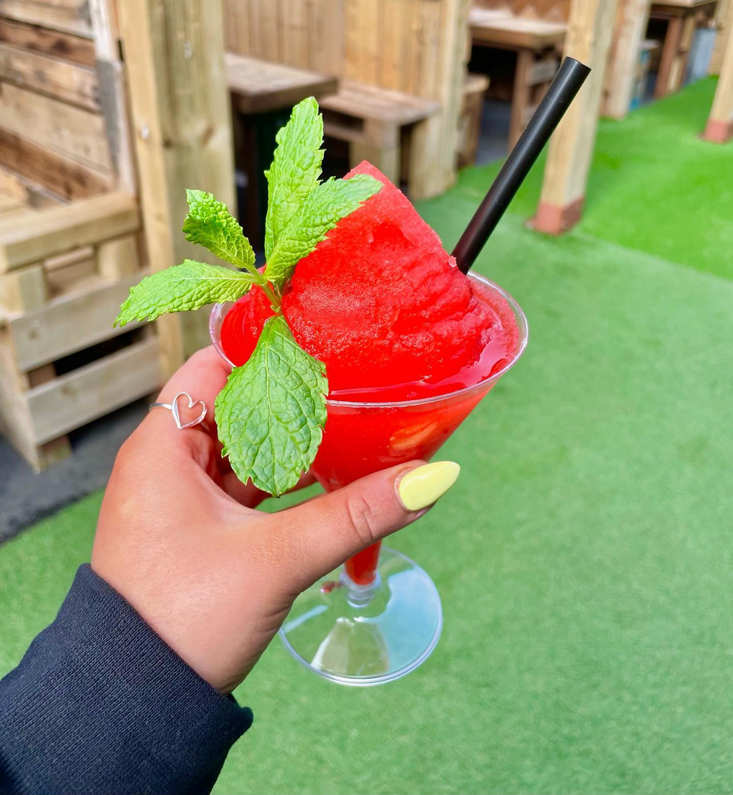 Person holding a drink at Oot the Back, Orkney Distilling's outdoor garden bar