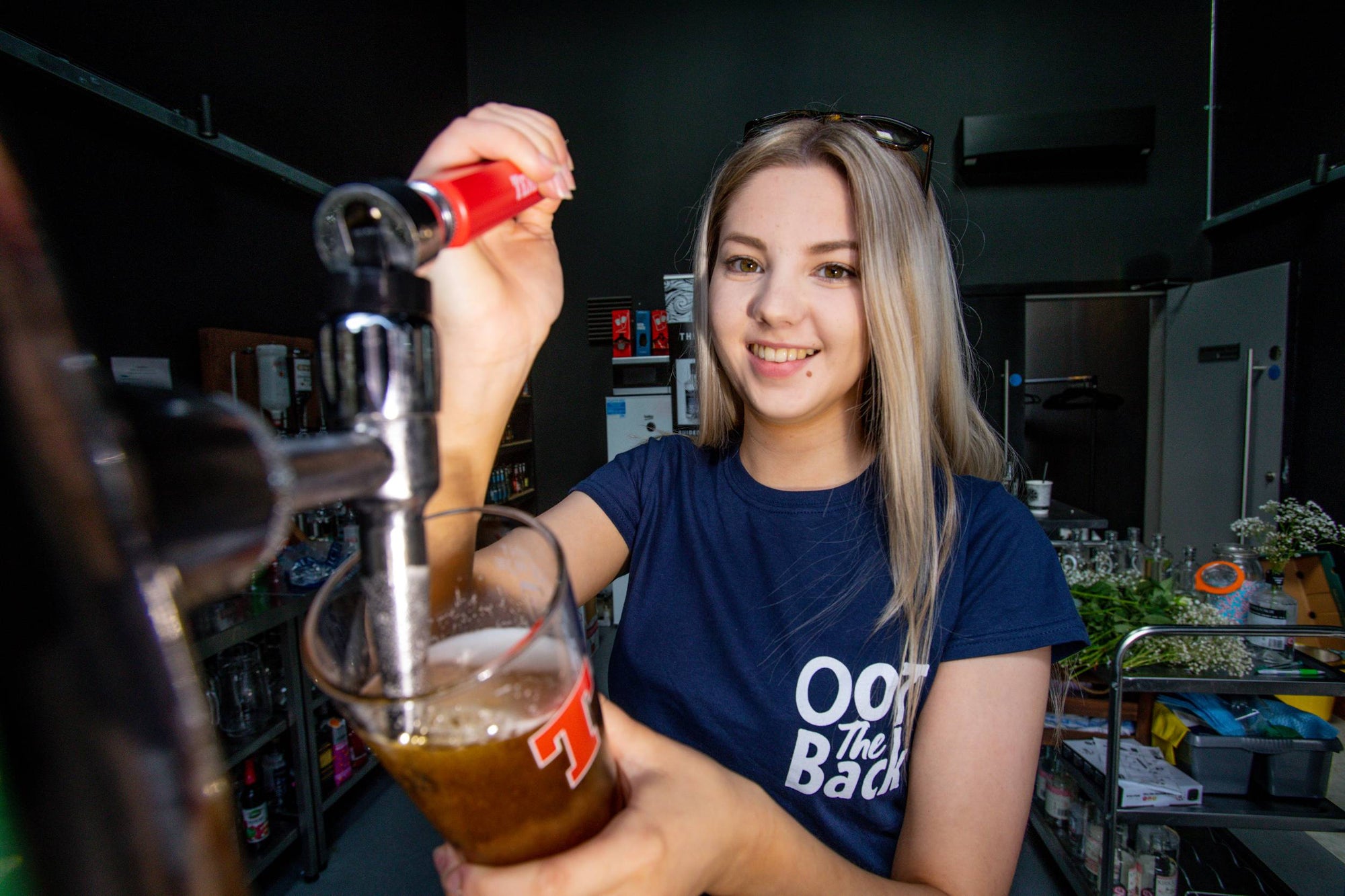 Server pouring a pint at Oot the Back - Orkney Distilling's outdoor garden bar